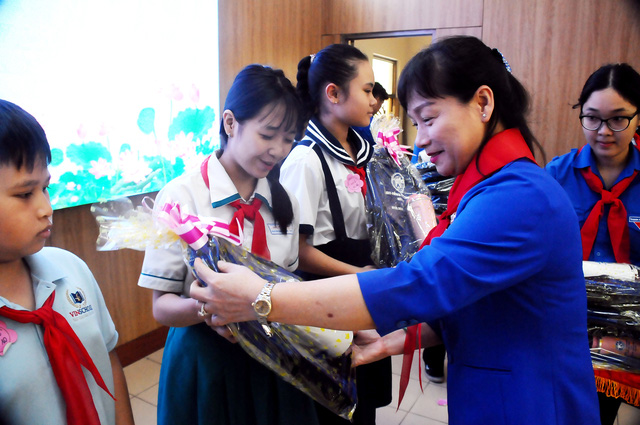 Cô Thái Thị Hồng Nga (phó Chủ tịch UBND quận Bình Thạnh) tặng quà cho các bạn đội viên. Ảnh: NGUYỄN HƯNG