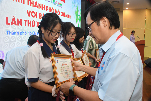 Chú Trần Anh Tuấn (phó gíám đốc Bảo tàng Tôn Đức Thắng ) trao thưởng cho các thí sinh đạt giải - Ảnh: NGUYỄN HƯNG