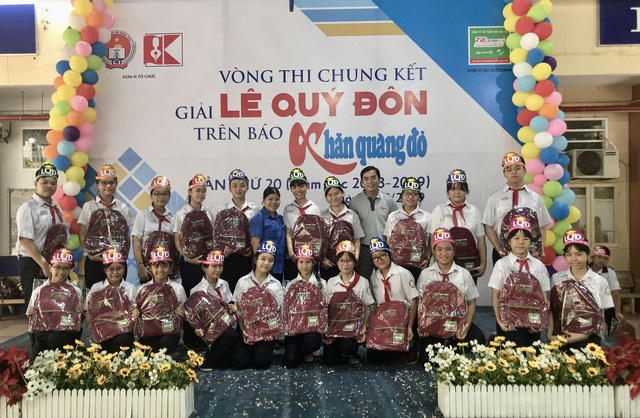 Cô Nguyễn Thị Thảo Trang (áo xanh) và chú Nguyễn Khắc Cường (nguyên Tổng Biên tập báo Khăn Quàng Đỏ, nay là Phó Tổng Biên tập báo Tuổi Trẻ) chụp hình lưu niệm với các bạn trường THCS Nguyễn Du (quận Gò Vấp) dự thi Vòng Chung kết Giải Lê Quý Đôn trên báo Khăn Quàng Đỏ năm học 2018-2019 -  ẢNH: NVCC