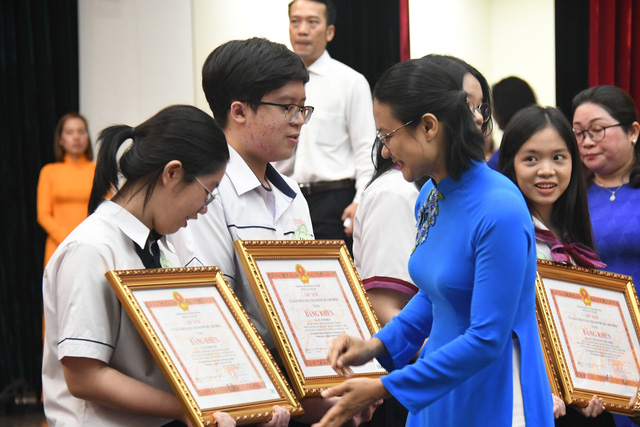 Chị Trần Thu Hà (phó Bí thư Thành Đoàn TP.HCM) trao Bằng khen cho các bạn học sinh giỏi - Ảnh: NGUYỄN HƯNG