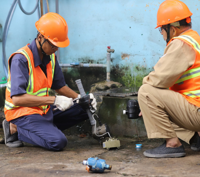 Nhân viên Công ty CP Cấp nước Gia Định lắp đặt đồng hồ nước thông minh cho khách hàng - Ảnh: C.T.
