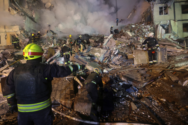 Lực lượng cứu hộ tại một tòa nhà chung cư hư hại do tên lửa Nga, Dnipro, Ukraine, ngày 14-1 - Ảnh: REUTERS