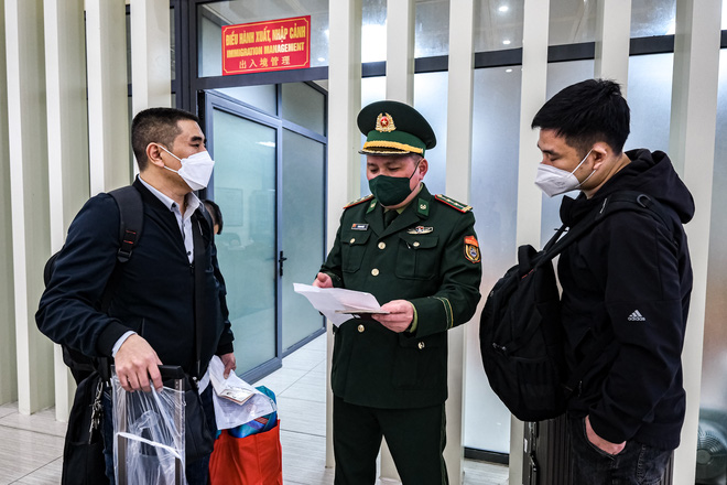 Cán bộ biên phòng giải thích cho công dân Trung Quốc những quy định liên quan đến giấy xét nghiệm COVID-19 theo phương pháp PCR đúng quy định theo yêu cầu của Đại sứ quán Trung Quốc - Ảnh: NAM TRẦN