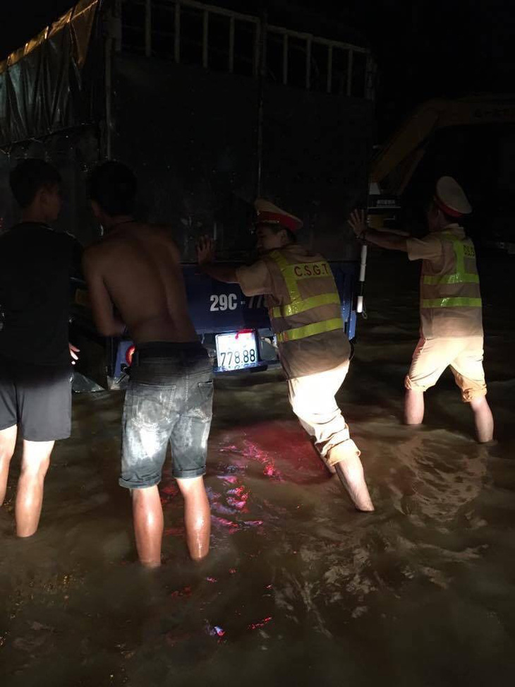 CSGT Hà Nội đẩy xe giúp dân qua vùng lũ trong đêm - Ảnh 1.