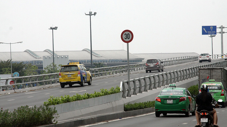 Xe bò 30km/h lên cầu vượt cổng sân bay Tân Sơn Nhất - Ảnh 1.