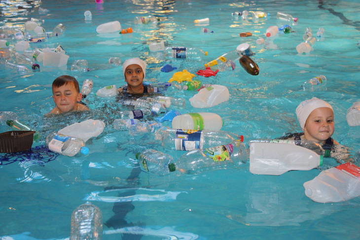 Trường cho học sinh bơi trong bể ô nhiễm để dạy về rác nhựa - Ảnh 1.