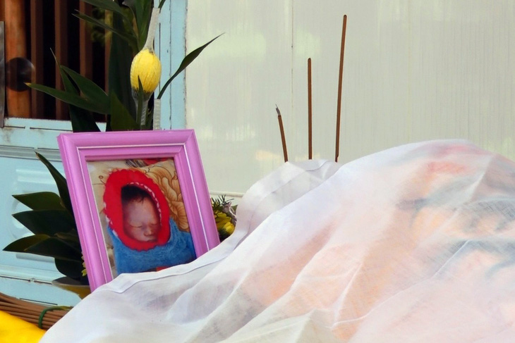 Bé gái sơ sinh nằm chết trong túi xách treo trước cổng chùa - Ảnh 1.