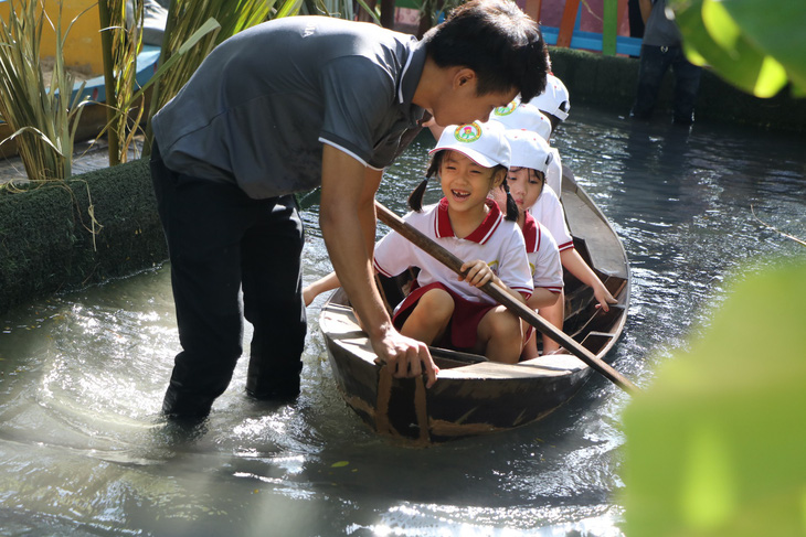 Học sinh Sài Gòn cười tít mắt khi đi xuồng trong... trường học - Ảnh 2.