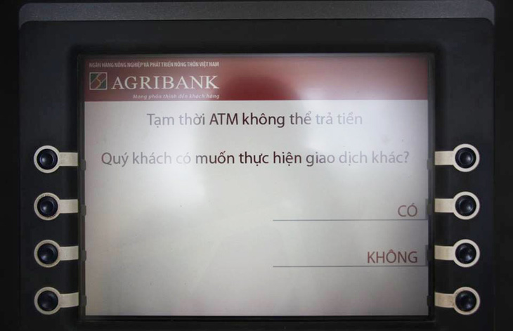 ATM ăn tết sớm, khách hàng khổ sở chờ rút tiền - Ảnh 1.