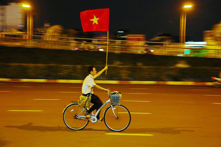 Nam sinh Sài Gòn ung dung đạp xe với lá cờ người lạ tặng - Ảnh 1.
