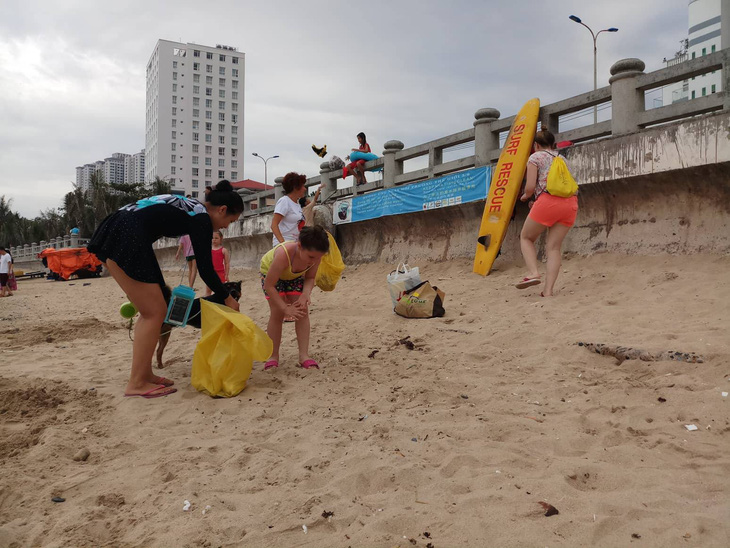 Nhóm khách Nga dọn rác trên bãi biển Nha Trang - Ảnh 1.