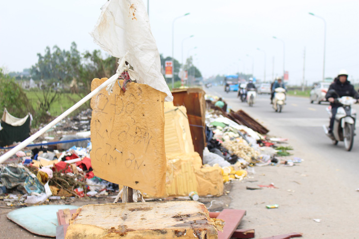 Hà Nội: Đổ trộm hàng đống rác ven quốc lộ, lấn nửa đường xe máy - Ảnh 3.