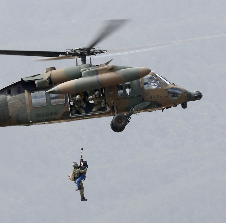Nước Nhật chạy đua cứu hộ, một cụ bà rơi 40 mét từ trực thăng xuống đất - Ảnh 1.