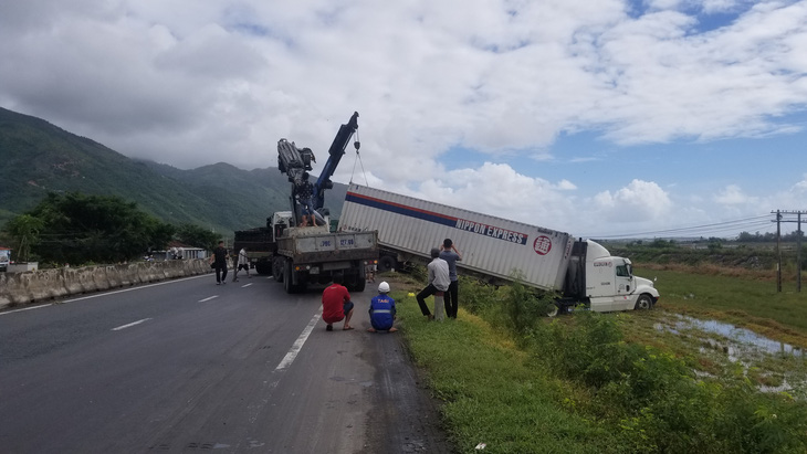 Hai xe tải lao xuống ruộng khi di chuyển trong bão nghi do mất lái - Ảnh 2.