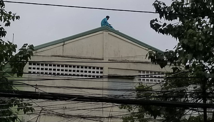 Người đàn ông trèo lên bảng chữ tầng 23 tiếp tục leo lên nóc nhà Bệnh viện Đà Nẵng - Ảnh 1.