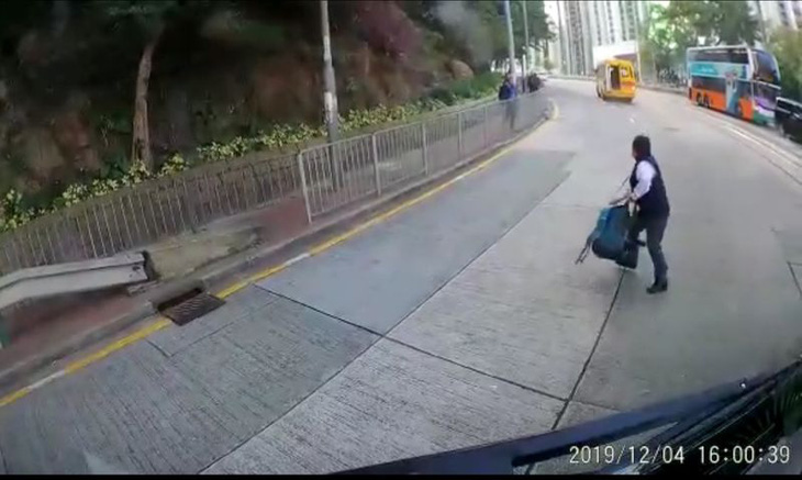 Học sinh tiểu học Hong Kong rơi xuống đường khi xe đưa rước đang chạy - Ảnh 1.