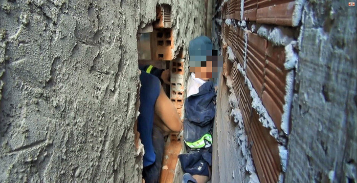 Cảnh sát cứu bé trai 7 tuổi kẹt giữa hai vách tường - Ảnh 1.