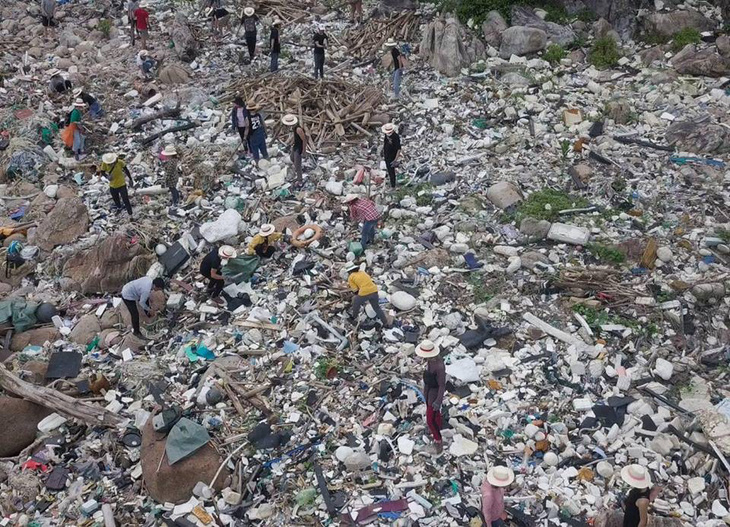 Hàng chục bạn trẻ leo lên bãi rác khủng ở Đá Đen dọn rác trong mưa - Ảnh 2.