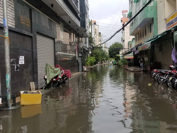 Chiều chủ nhật mưa rơi, người dân TP.HCM lại bì bõm lội nước - Ảnh 4.