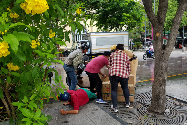 Xe bồn tưới nước đi qua, xe máy ngã nhào trên phố đi bộ Nguyễn Huệ - Ảnh 1.