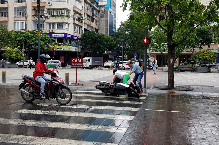 Xe bồn tưới nước đi qua, xe máy ngã nhào trên phố đi bộ Nguyễn Huệ - Ảnh 3.