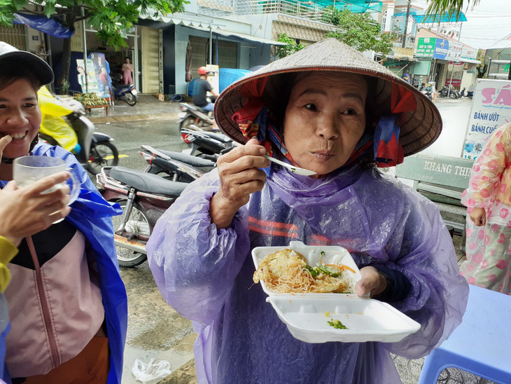 Bạn trẻ Phú Quốc phát cơm nóng cho bà con nghèo ngày mưa bão - Ảnh 1.