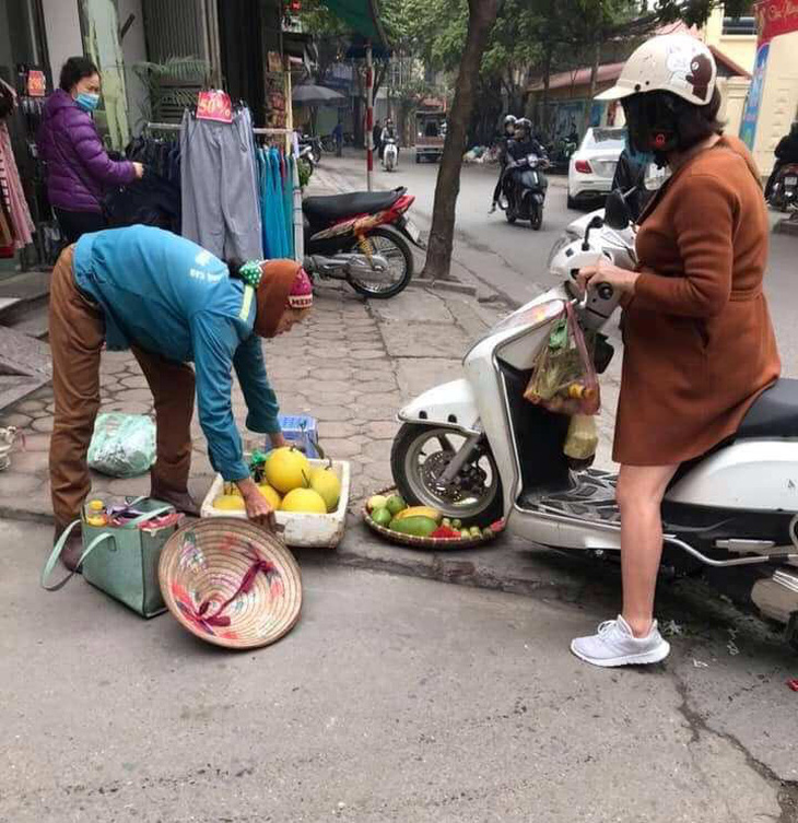 Người phụ nữ cán xe máy qua mẹt trái cây của chị bán hàng rong - Ảnh 1.