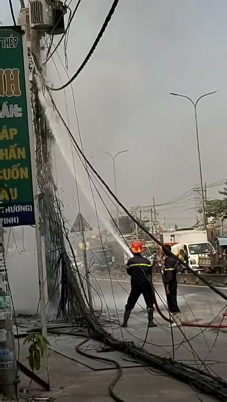 Cột điện ven quốc lộ ở TP.HCM bốc cháy ngùn ngụt kèm theo nhiều tiếng nổ - Ảnh 3.