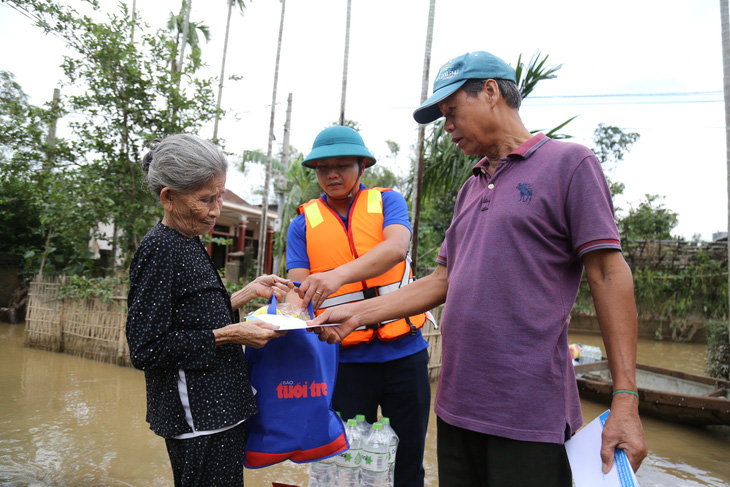 Bà con vùng lũ sẻ chia với nhau quà bạn đọc báo Tuổi Trẻ - Ảnh 10.