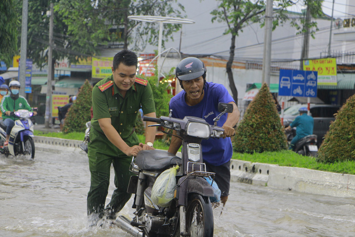 Công an, dân phòng Cần Thơ ra đường đẩy xe giúp dân vượt triều cường - Ảnh 4.