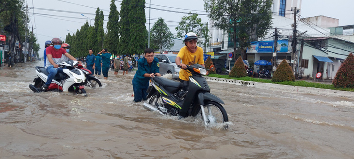 Công an, dân phòng Cần Thơ ra đường đẩy xe giúp dân vượt triều cường - Ảnh 1.