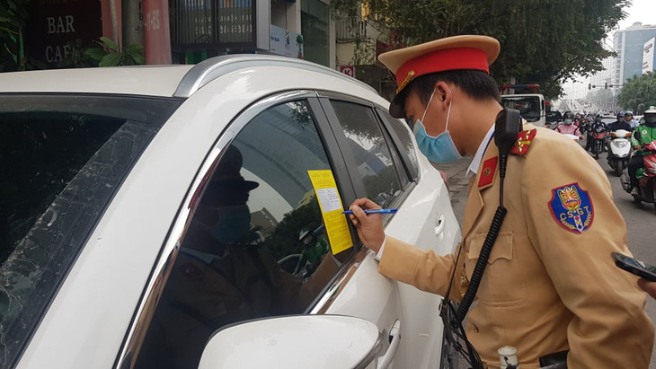 Cảnh sát giao thông Hà Nội dán thông báo phạt nguội trên kính ôtô - Ảnh 1.