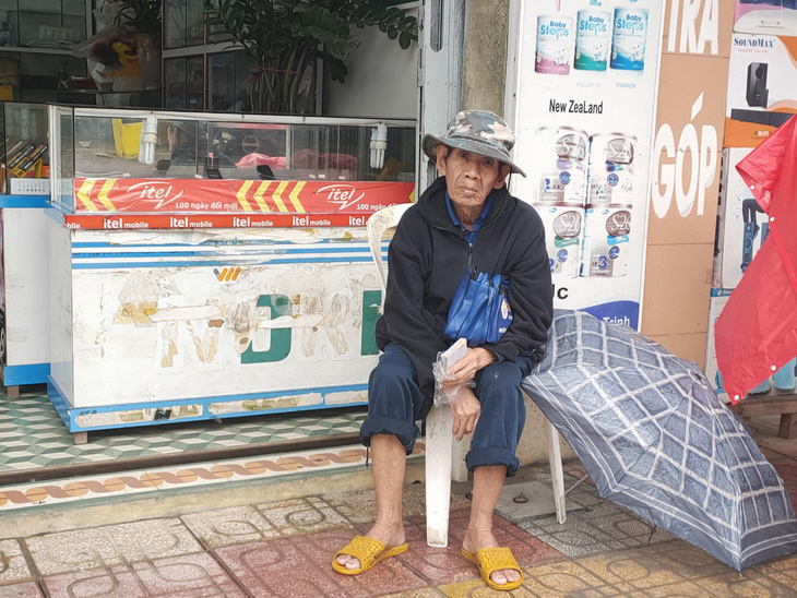 Những người già bán vé số đội mưa, co ro trong giá rét để mưu sinh - Ảnh 5.