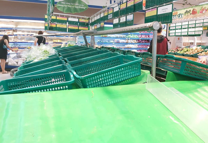 Nhiều khay hàng thiết yếu tại các siêu thị ở TP.HCM bị vét sạch - Ảnh 2.