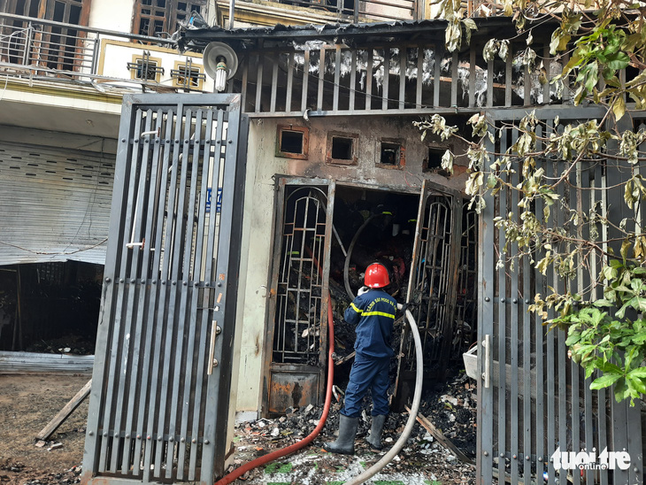 Căn nhà chứa vải vụn cháy ngùn ngụt, cảnh sát phải phá tường dập lửa - Ảnh 1.