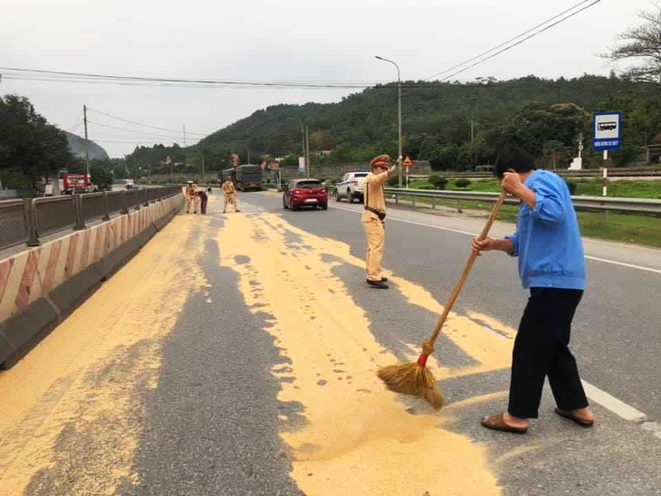 Cảnh sát giao thông và người dân giúp tài xế gom 4 tấn đỗ tương rớt xuống đường - Ảnh 3.