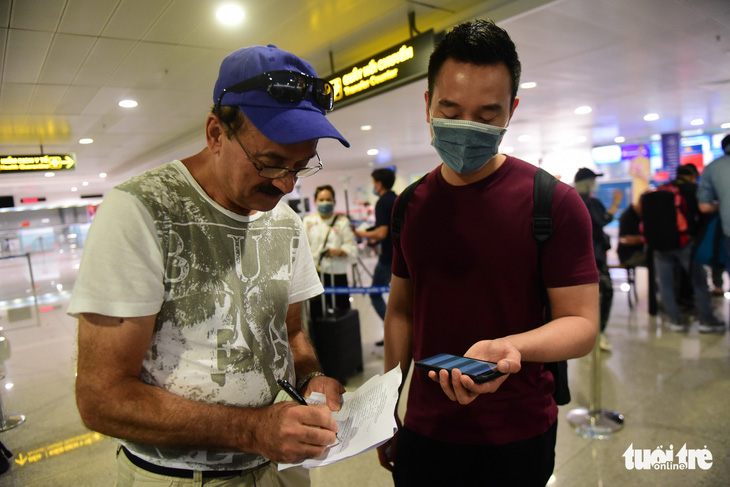 Xếp hàng chờ khai, nộp thông tin khai báo y tế ở sân bay Tân Sơn Nhất - Ảnh 3.