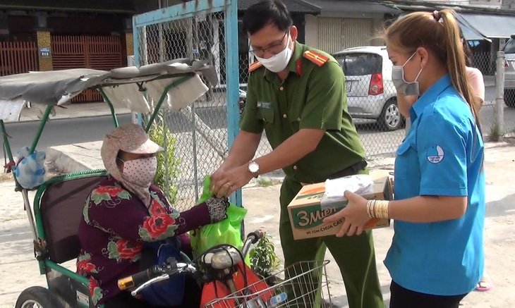 Công an xã giúp người bán vé số nghèo trong mùa dịch - Ảnh 1.