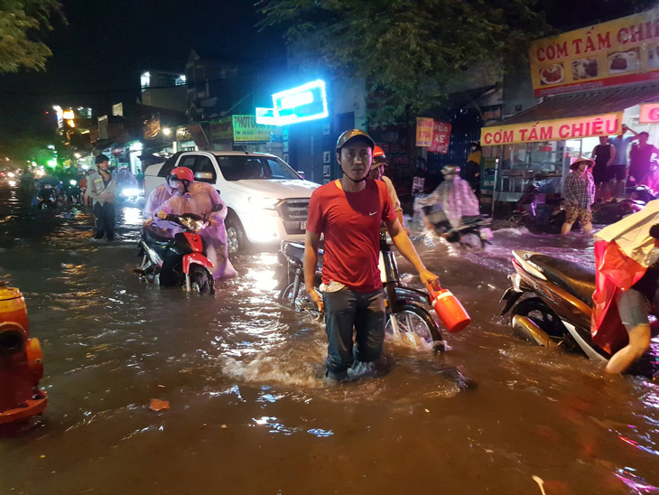 TP.HCM mưa lớn, người dân lội biển nước mênh mông về nhà - Ảnh 6.