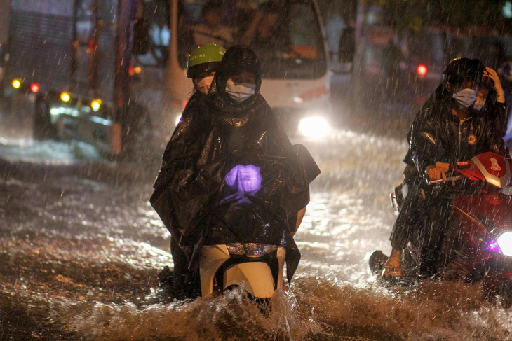TP.HCM mưa liên tục nhiều giờ, dân bì bõm lội nước trên hàng loạt tuyến đường - Ảnh 1.