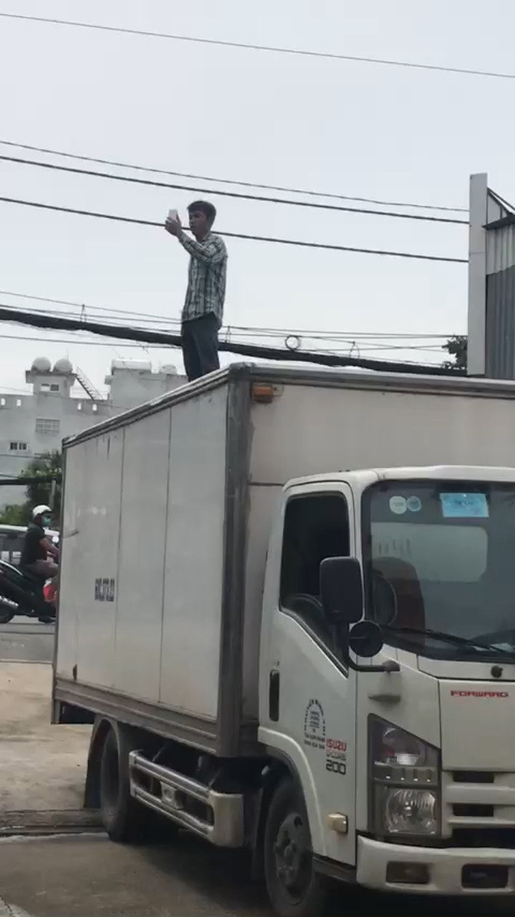 Một thanh niên cầm cây leo lên mui xe tải đòi uýnh người qua lại - Ảnh 2.