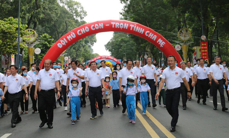 Phó thủ tướng Trương Hòa Bình đi bộ vận động đội mũ bảo hiểm cho trẻ em - Ảnh 1.