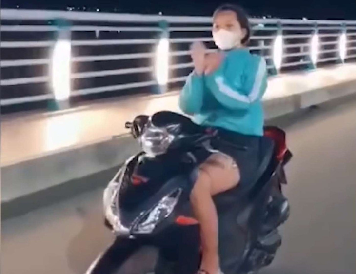 Phạt cô gái múa quạt, thả tim khi chạy xe máy trên cầu Thạch Bích - Ảnh 1.