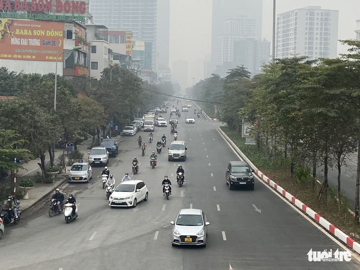 Sương mù giữa trưa Hà Nội, phải bật đèn chạy xe trên đường - Ảnh 2.