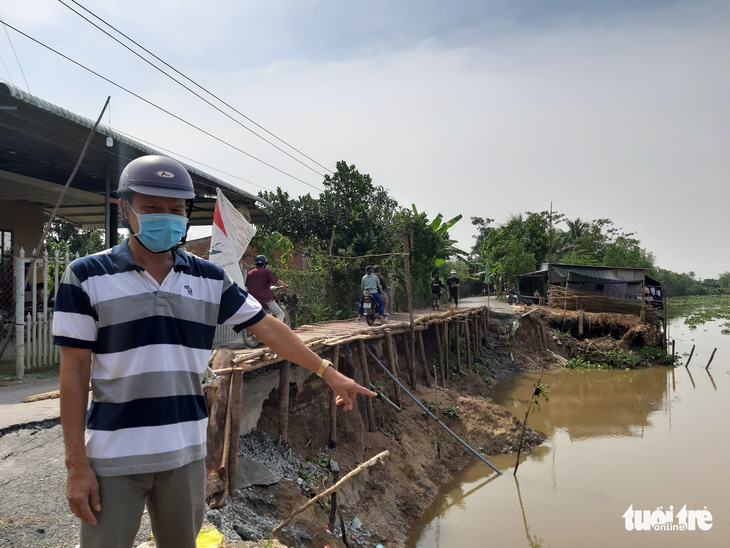 Một khúc huyện lộ 54B đổ xuống sông Ba Rài, dân muốn đi chợ, ra xã phải đi vòng 5 cây số - Ảnh 1.