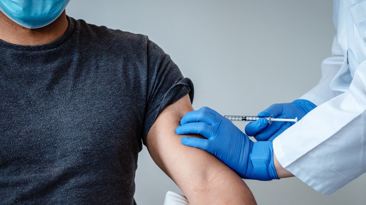 WHO khuyến cáo vaccine ngừa COVID-19 gây triệu chứng giống cúm - Ảnh 1.