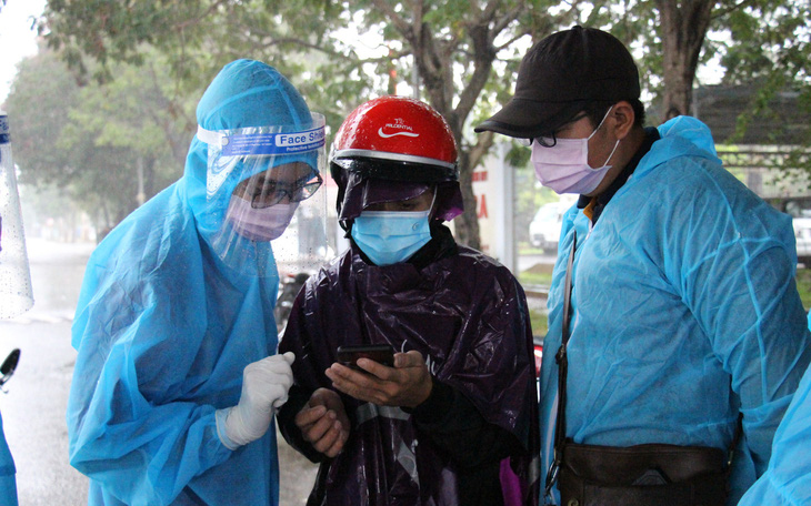 Tình nguyện viên dầm mưa dãi nắng trực chốt chống dịch COVID-19