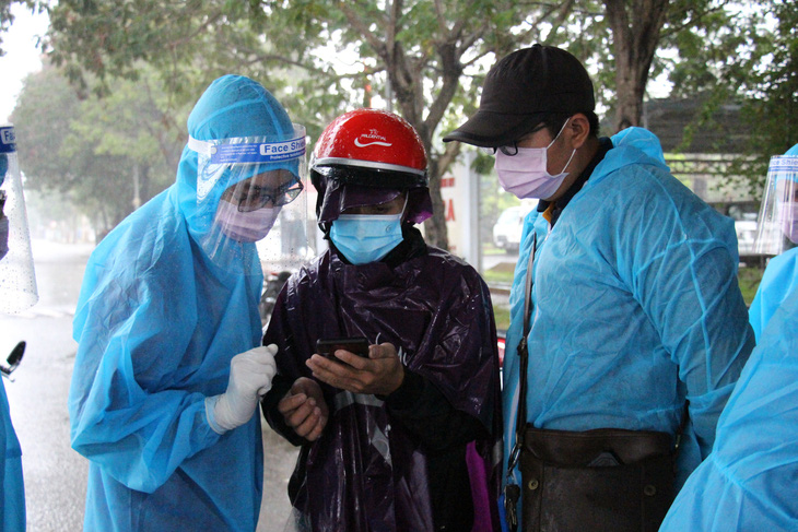 Tình nguyện viên dầm mưa dãi nắng trực chốt chống dịch COVID-19 - Ảnh 2.