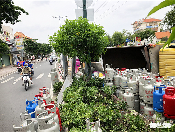 Lật xe chở gas, hàng chục bình gas văng xuống đường Phạm Văn Đồng - Ảnh 2.