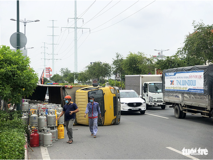 Lật xe chở gas, hàng chục bình gas văng xuống đường Phạm Văn Đồng - Ảnh 3.